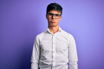 Obraz premium Young handsome business man wearing shirt and glasses over isolated purple background depressed and worry for distress, crying angry and afraid. Sad expression.