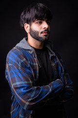 Portrait of young handsome bearded Indian hipster man