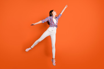 Full length profile side photo of positive cheerful girl jump hold hand want catch parasol feel funny emotions wear casual style clothing isolated over orange color background