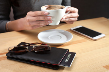 tourist. The girl drinks coffee
On the table lies a purse glasses and phone