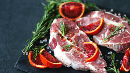 Pork steaks marinated with rosemary and red orange. Raw meat. Keto Paleo. Pegan diet. Pork with citruses. Recipe. Selective focus. Macro.