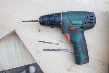 Close up Electric drill, Drill set, Screwdriver set, adapter on wooden table background and copy space. Hammer drill or screwdriver, Electric cordless hand drill on wooden. maintenance home concept.