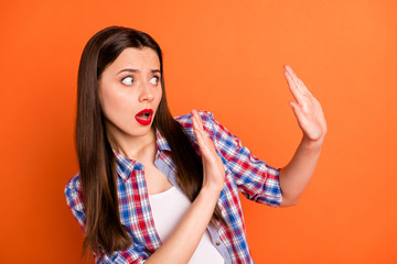 Close-up portrait of her she nice attractive scared worried straight-haired girl wearing checked shirt showing no sign aside isolated on bright vivid shine vibrant orange color background