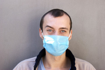 The image face of a young man wearing a medicine mask.