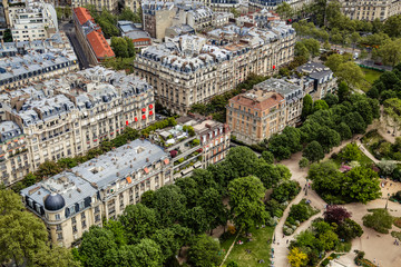 Top view from Eiffel Tower of famous Champs de Mars, historical streets, gardens, residential building and typical parisian rooftops with terraces. 7th arrondissement of Paris. France. Touristic place