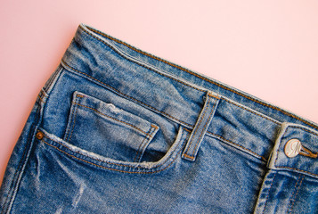 Jeans on a pink background. Jeans elements, pockets, seams in close-up. Ripped jeans.  Copy Space