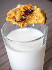 Chewy chocolate chip soft cookie on cup of milk