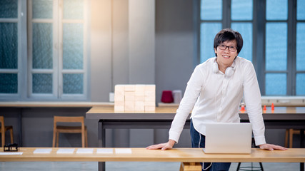 Smart Asian man university student using laptop computer while doing workshop in design studio. working with technology device for doing educational research project. Education concept