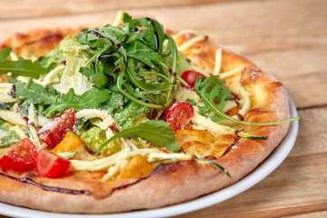 pizza with fresh vegetables on the wooden background