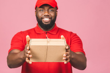 Delivery concept. African american delivery black man carrying parcel isolated over pink background.