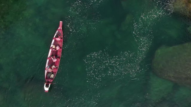 4k Aerial Top Down Shot of a Red Paddle Boat moving across the Crystal Clear Waters  towards the river Current of Dawki, Meghalaya
