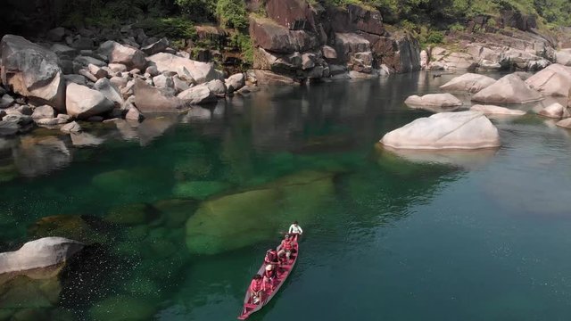 4k Aerial Reveal Shot of a Red Paddle Boat  with tourists ride with the Currents direction in the Crystal Clear Waters of Shnongpedang Dawki Meghalaya