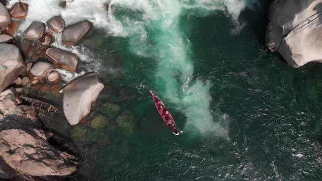 4k Aerial Top Down Shot of a Red Paddle Boat  halting in the currents of the Crystal Clear Green Waters of Dawki, Meghalaya