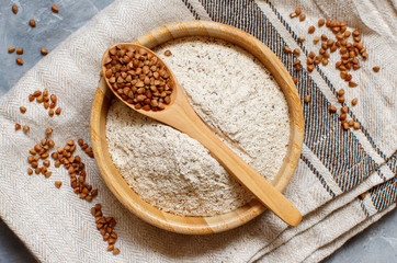 Buckwheat flour in a bowl and buckwheat grain in a spoon
