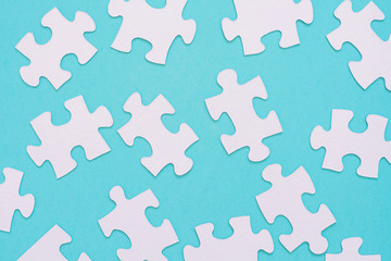 White puzzle pieces scattered on a blue background