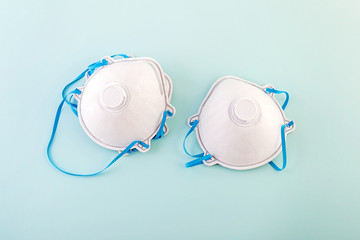 Medical respirators lie on a blue background. The concept of protection against viruses, coronavirus, upper respiratory tract infections.