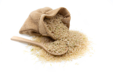 Raw brown rice in brown sack, healthy food background.