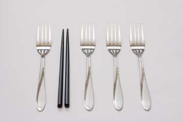 Business concept. Four forks and wooden stick on a grey background. Out of the box thinking, be different concept