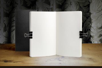 Notebook mockup on a background of wooden table and drapery