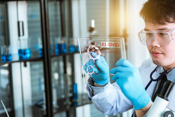 Doctor holding transparent tablet with futuristic screen tablet. Research for antiretroviral drugs.