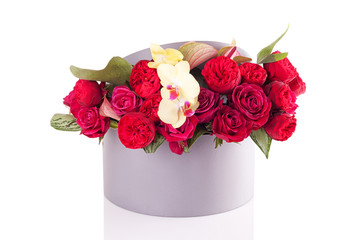 a bouquet of flowers in a round box on a white background