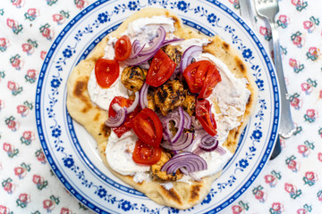 Greek Pita Chicken Souvlaki Kalamaki wrap opened with Tzatziki yogurt sauce, chicken skewers, red onion and tomato.
Traditional greek street food.