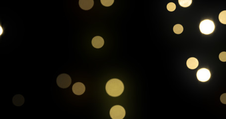 Bokeh light background, gold shine abstract particles with blur flare effect. Golden glitter glowing shiny bokeh light sparkles on black background