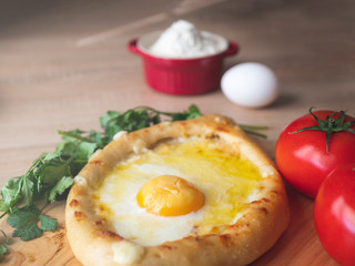 Khachapuri with egg and cheese. Georgian traditional cuisine.