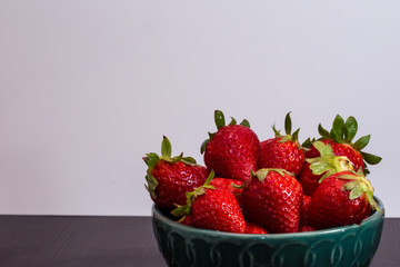 Horizontal closeup Green bowl full of strawberries