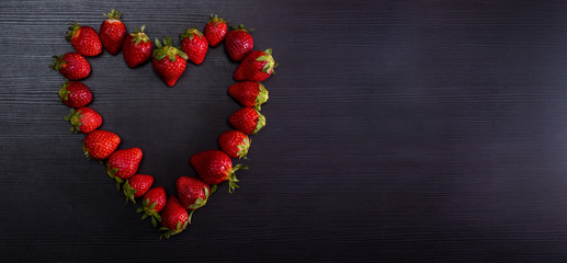 BANNER Fresh strawberries in heart shape on old wooden background. Love concept. 