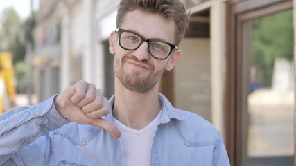 Thumbs Down by Casual Young Man Standing Outdoor by Road