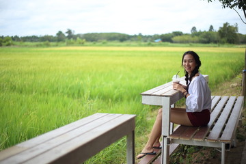 Woman sitting and watching rice fields Rayong, Thailand