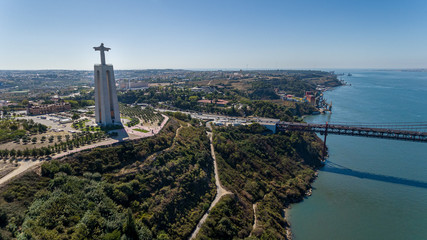 Fototapeta premium Aerial. Panorama from sky, a 25 de Abril Bridge and a statue of Jesus Christ. Lisbon.