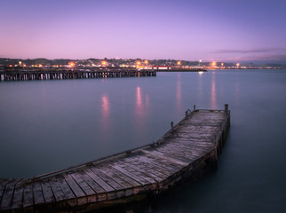 Purple sunset over the harbor with jetty in foreground. Shot in Oamaru, New Zealand. 