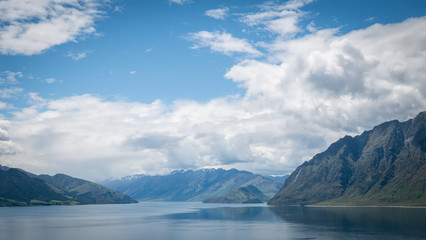 Fototapeta na wymiar Scenic alpine lake surrounded by mountains shot on sunny day. Location is lake Hawea, New Zealand. 