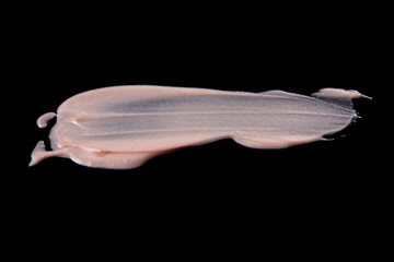 Pearl Foundation Cream Stroke and Texture on Black Background.