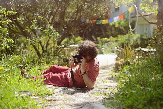 Portrait of man enjoying taking photos at home in his garden