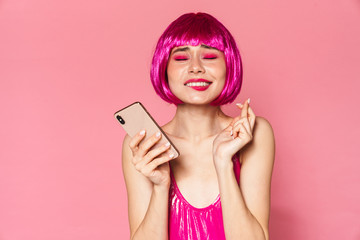 Image of party girl holding fingers crossed and using mobile phone