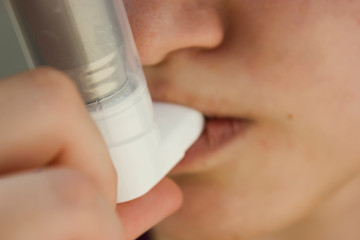 World Asthma Day May 5.anti-asthma inhaler on a blue background.teenager uses an inhaler