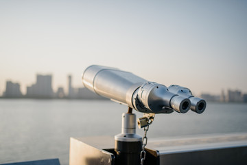 telescope with city skyline