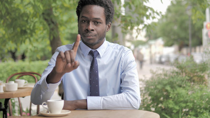 No, African Businessman Shaking Head To Reject while Sitting in Outdoor Cafe