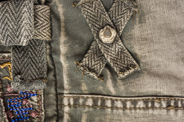 clothing items stonewashed cotton fabric texture with seams, clasps, buttons and rivets, macro