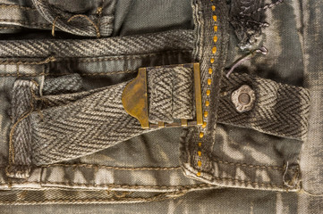 clothing items stonewashed cotton fabric texture with seams, clasps, buttons and rivets, macro