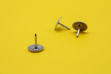 Pushpins isolated on yellow background
