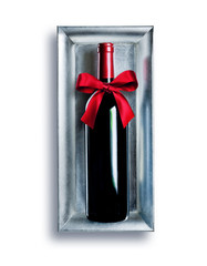eine Flasche Rotwein mit einer roten Schleife liegt auf einer silbernen Schale