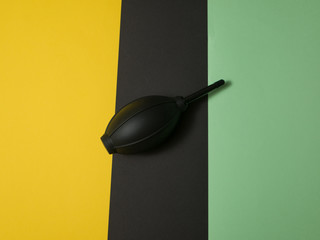 Black rubber air blower pump dust cleaner isolated on colored background. Copy space.