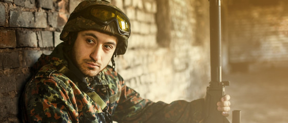 A man is a military soldier in a helmet and camouflage clothing. Pensive soldier resting from a military operation.