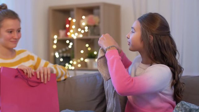 people, friendship and leisure concept - happy teenage girls with shopping bags bragging at home