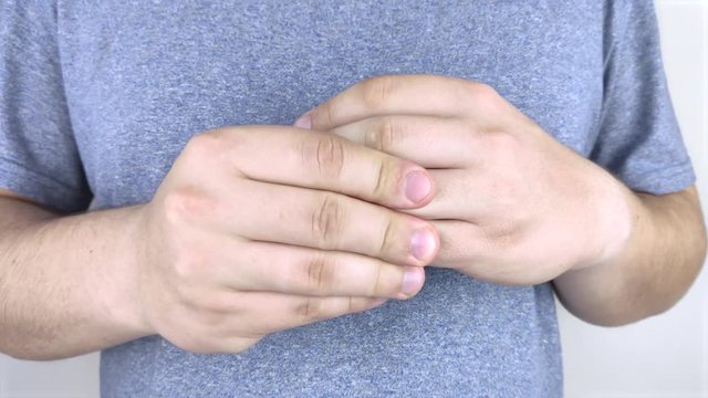 Pain in the joints of the fingers. A man rubs his fingers, which hurt and pull. Arthritis of the joints and its treatment.