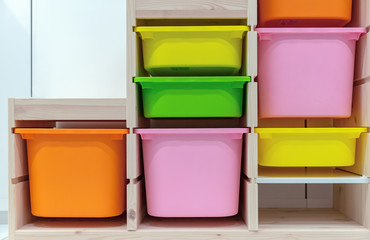 Wooden rack with multi-colored retractable plastic boxes.
